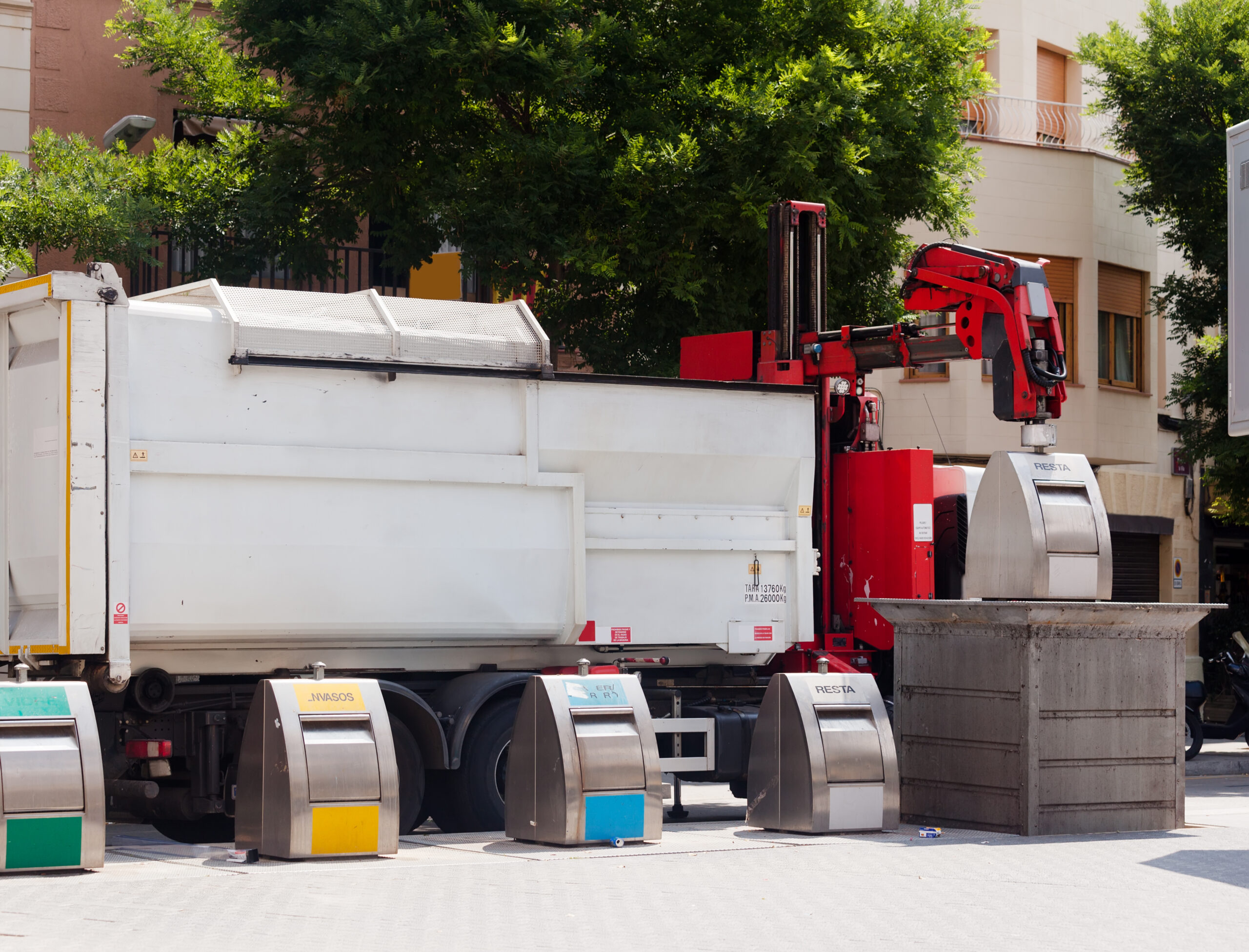 Recycling truck picking up bin at city street. Spain